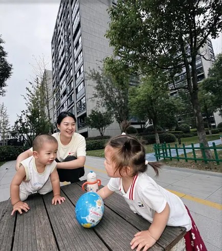 照护人员陪伴孩子在户外活动的实景
